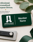 Professional personalized laser engraved name badge for Junior League Palo Alto Mid Peninsula nonprofit organization with magnetic back shown on neutral background with eucalyptus greenery and green ribbon