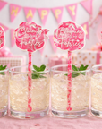 Four glasses of a creamy beverage with straws and 'Blooming Forties' signs on a pink background.