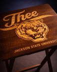 Close-up of dark wood folding tray table with engraved tiger crest and Jackson State University