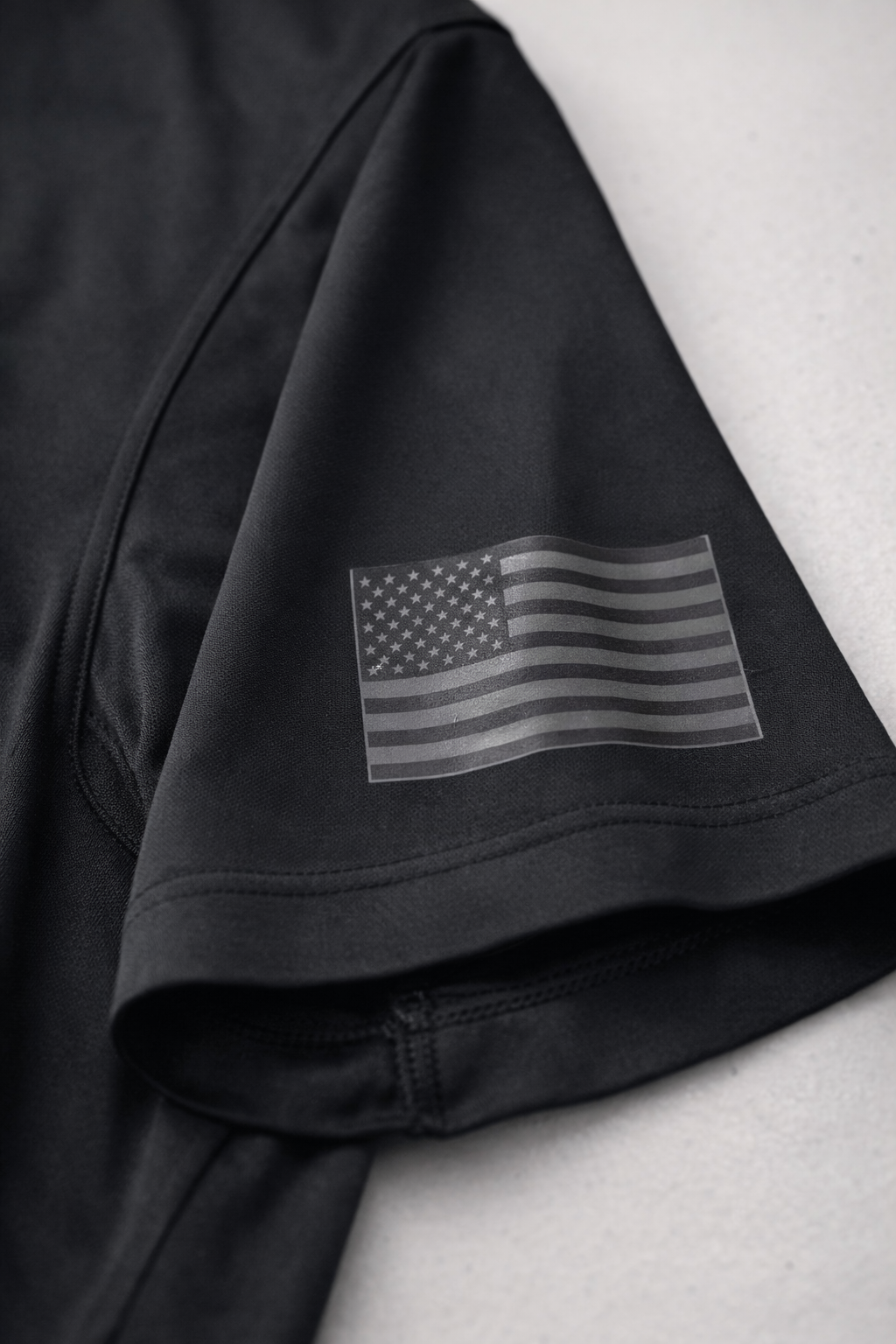Black t-shirt with American flag graphic on a white background