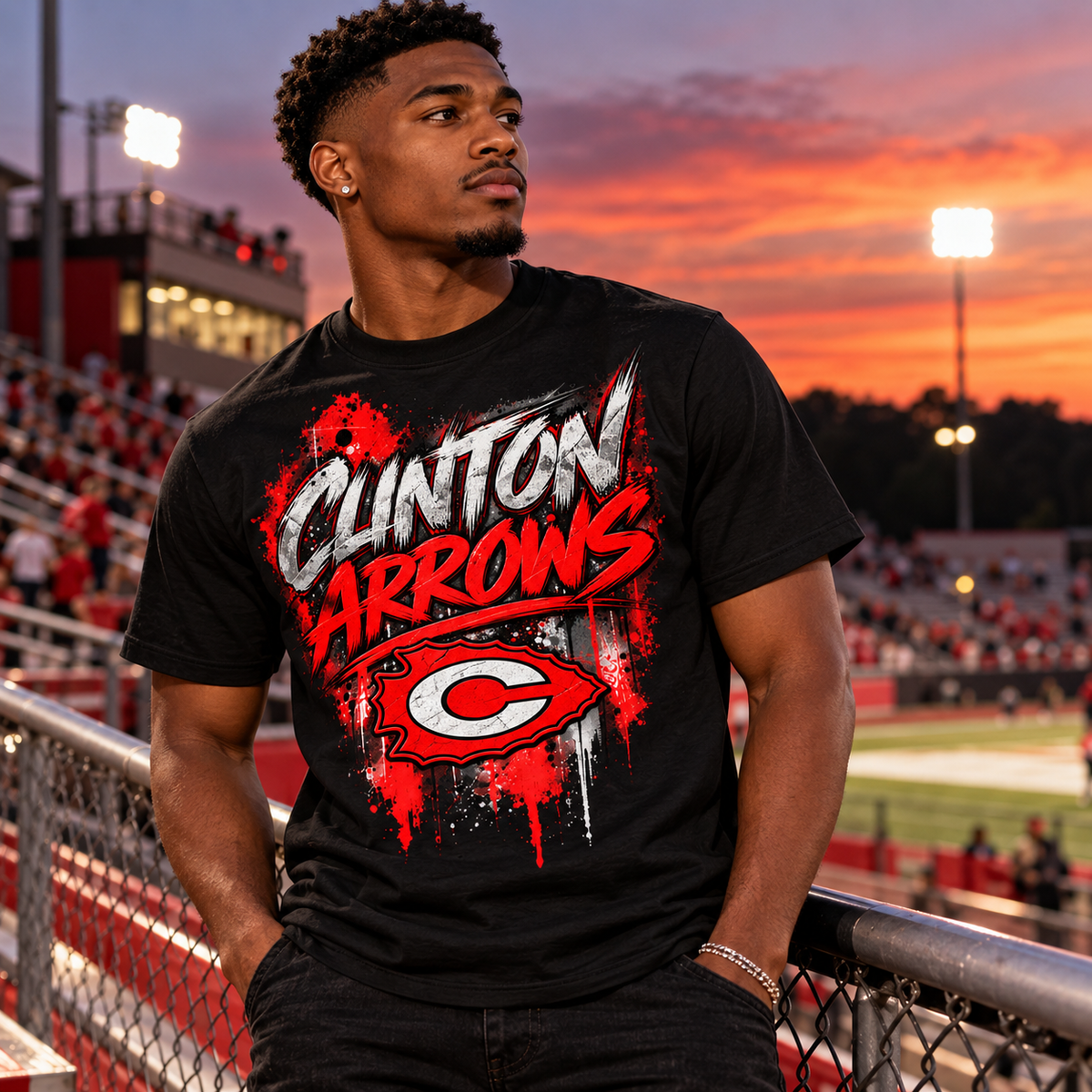 Young man wearing black Clinton Arrows graffiti T-shirt at a football stadium