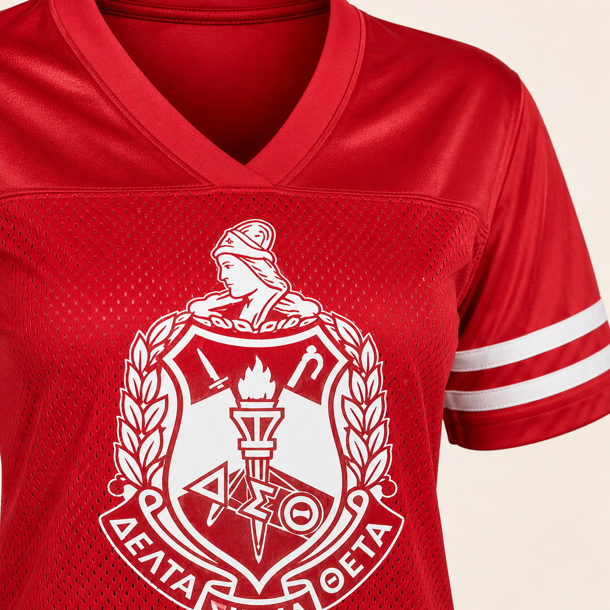 A close-up of a red mesh V-neck athletic jersey with a large white fraternity-style crest printed on the front and white sleeve stripes.
