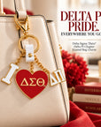 Delta Sigma Theta Delta Pi enamel bag charm attached to an elegant cream handbag with polished gold-tone hardware