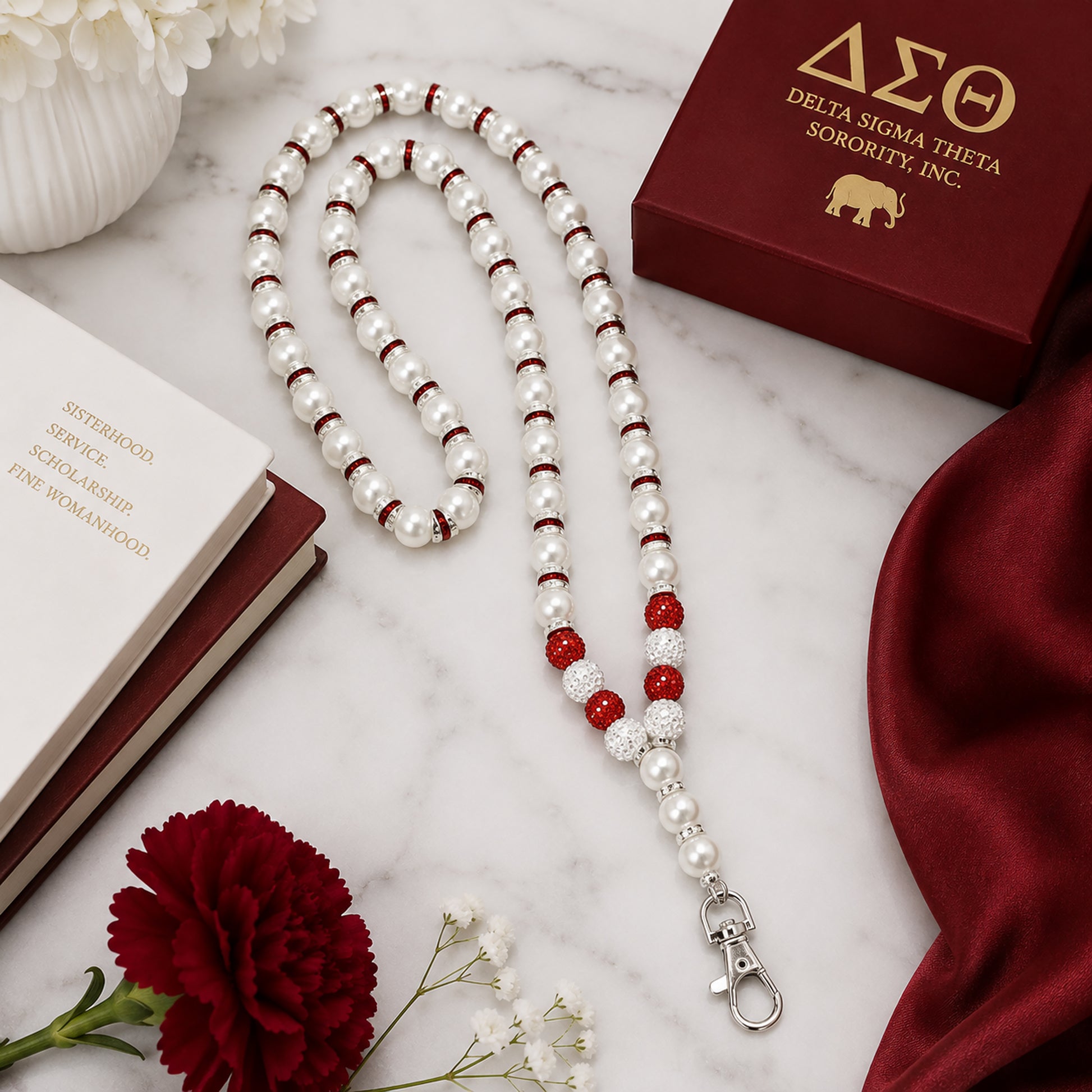 Flat lay of Delta Sigma Theta pearl beaded lanyard necklace with crimson accent beads and rhinestone spacers