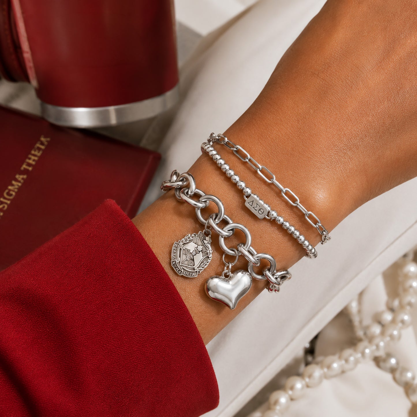 Delta Sigma Theta charm bracelet layered with coordinating silver bracelets for everyday sorority style.