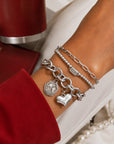 Delta Sigma Theta charm bracelet layered with coordinating silver bracelets for everyday sorority style.