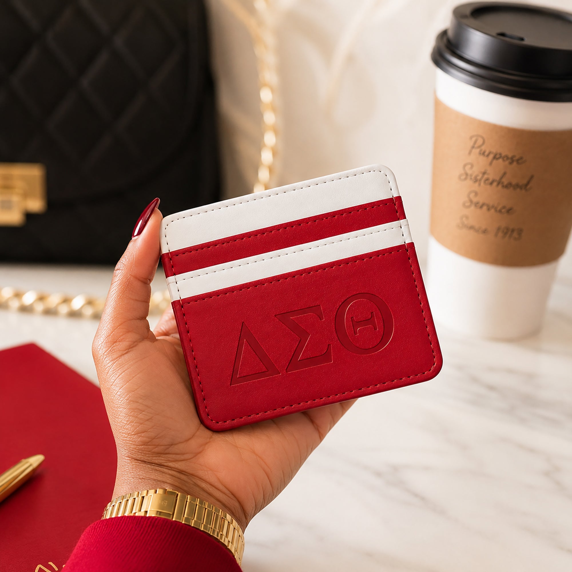 Crimson &amp; White Delta Sigma Theta faux leather slim wallet styled with a luxury handbag, coffee, planner, and everyday accessories.