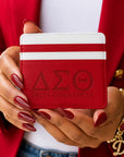 Woman holding the Crimson & White Delta Sigma Theta faux leather slim wallet while wearing a red blazer and gold accessories.