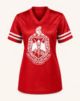 A red short-sleeve V-neck athletic jersey with white sleeve stripes and a large white Greek letter Sigma Beta crest on the front, displayed on a light cream background.
