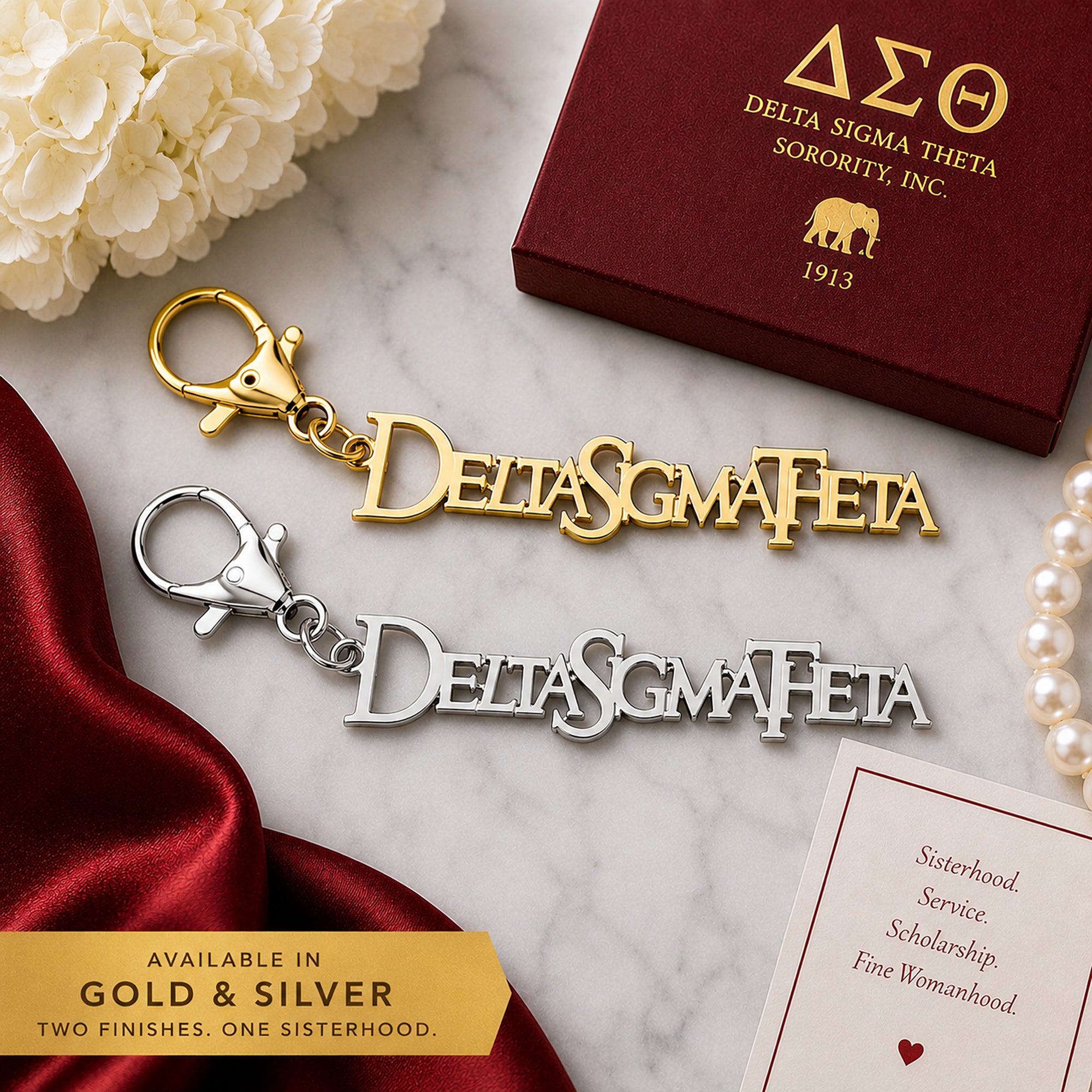 Officially licensed Delta Sigma Theta script logo keychain available in polished gold and silver finishes displayed side by side on a luxury marble flat lay.