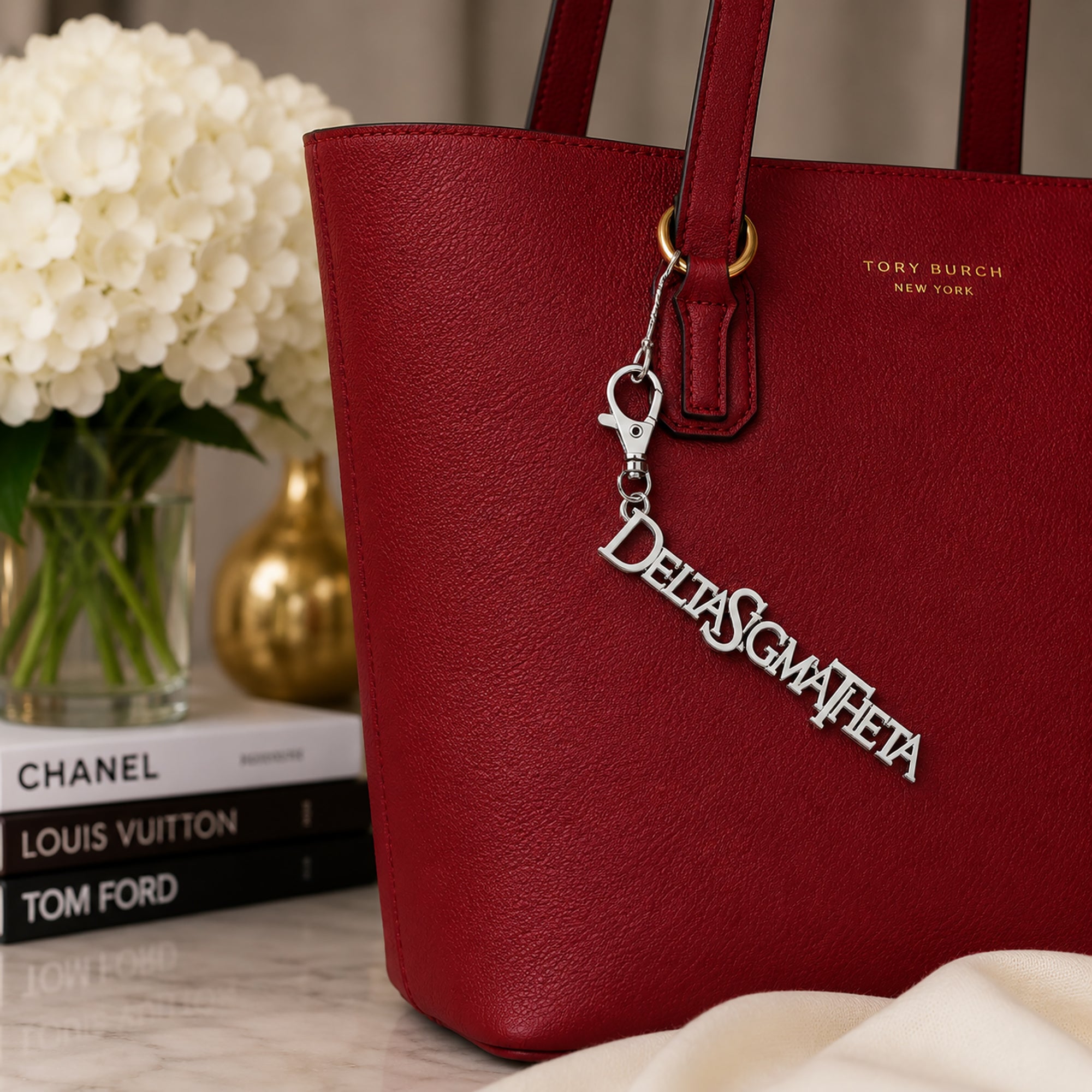 Delta Sigma Theta silver Greek letter bag charm attached to red tote bag