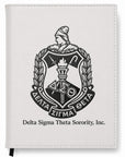 White notebook with Delta Sigma Theta Sorority, Inc. emblem on a white background