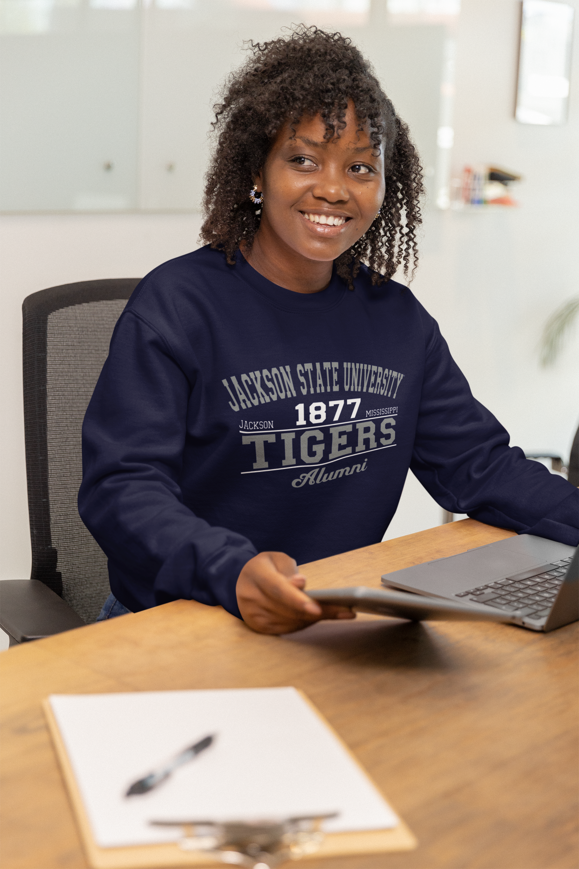 Woman wearing navy unisex crewneck sweatshirt with Tigers Alumni chest graphic