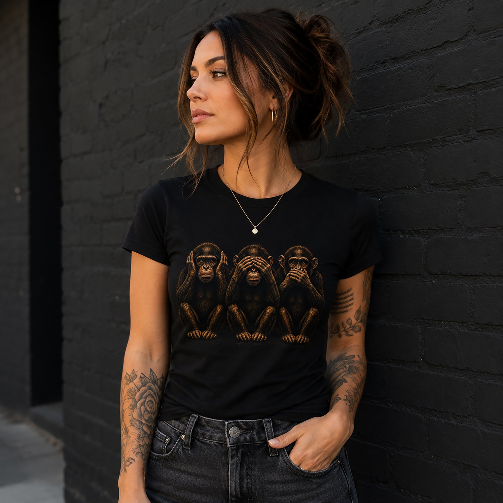 Woman wearing fitted black graphic t-shirt with hear no evil see no evil speak no evil monkey design