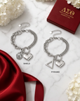Delta Sigma Theta Shield and Pyramid Charm Bracelets styled on marble with crimson gift box and white hydrangeas
