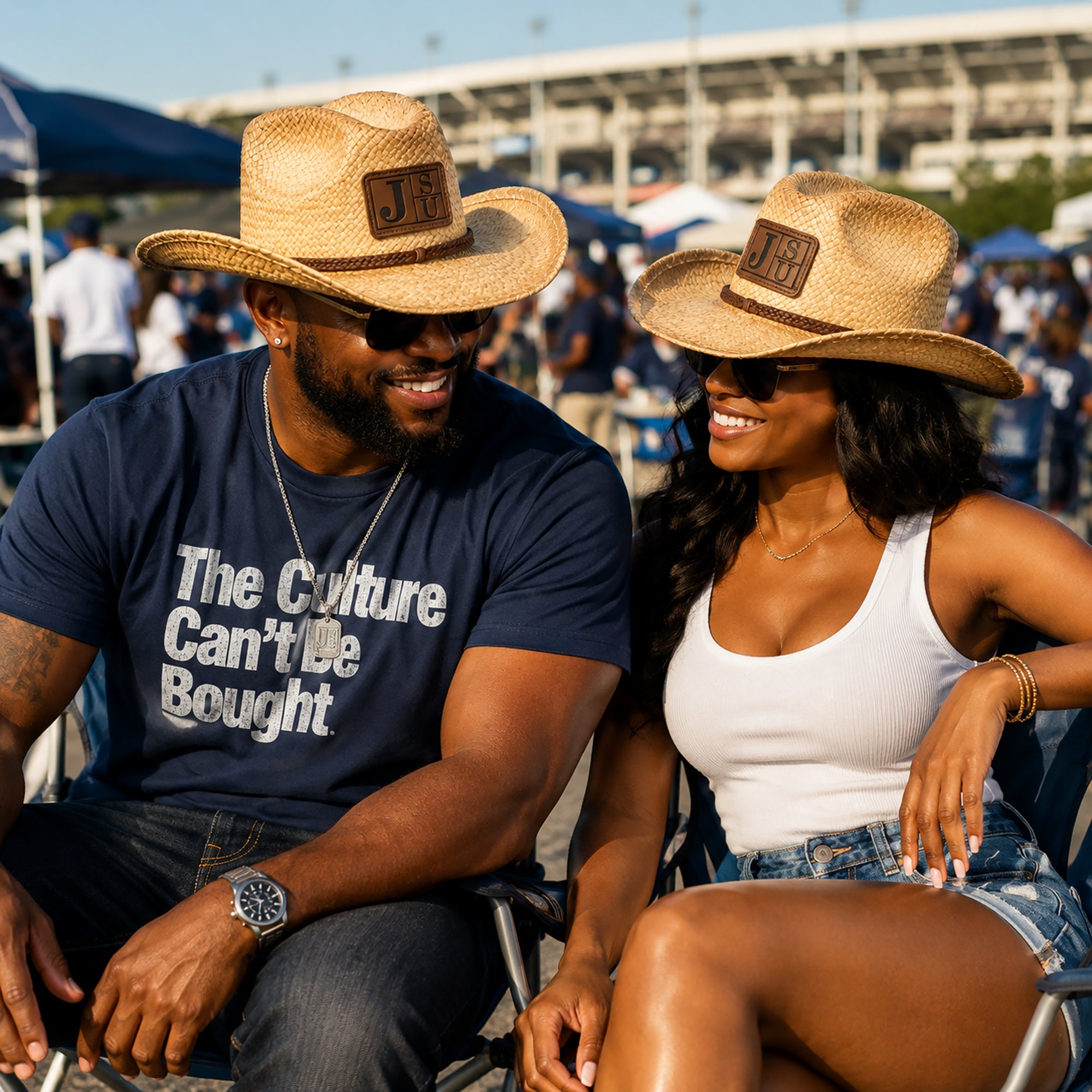 Black couple wearing Jackson State University JSU cowboy straw hats at a football game day tailgate.