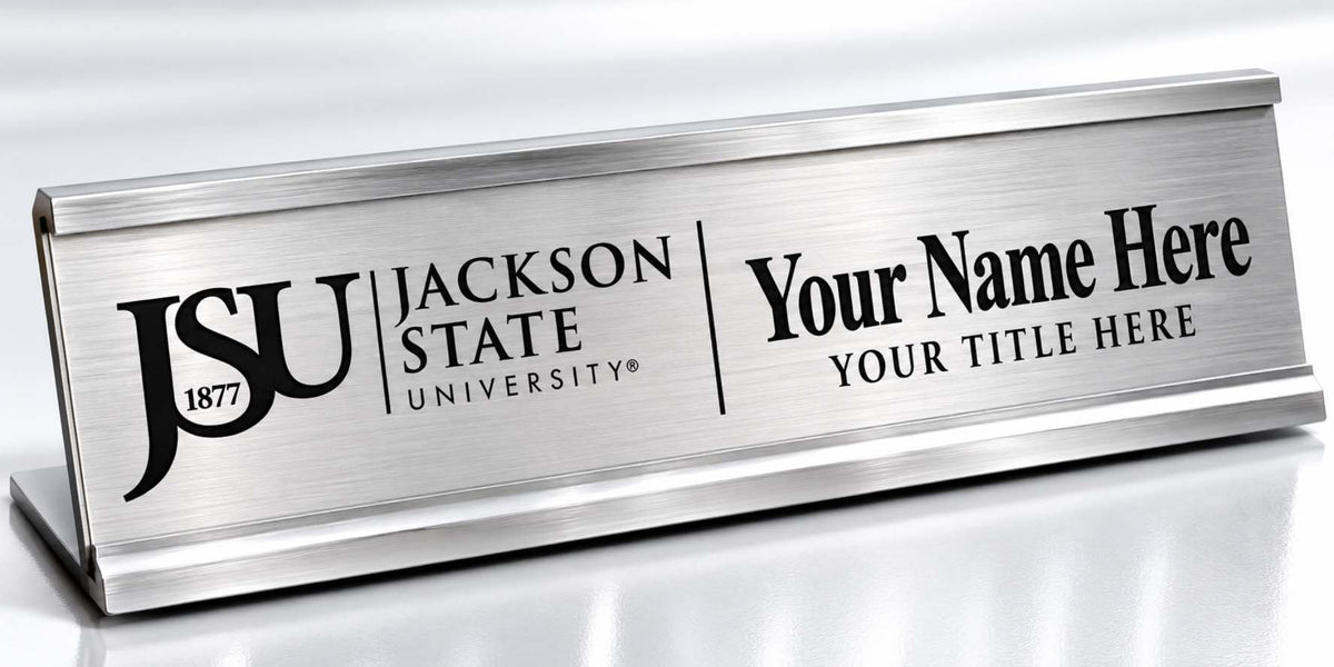 A brushed silver metal desk nameplate with black engraved text reading 'JSU Jackson State University' and 'Your Name Here' with 'Your Title Here' on a white background.