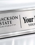 A brushed silver metal desk nameplate with black engraved text reading 'JSU Jackson State University' and 'Your Name Here' with 'Your Title Here' on a white background.