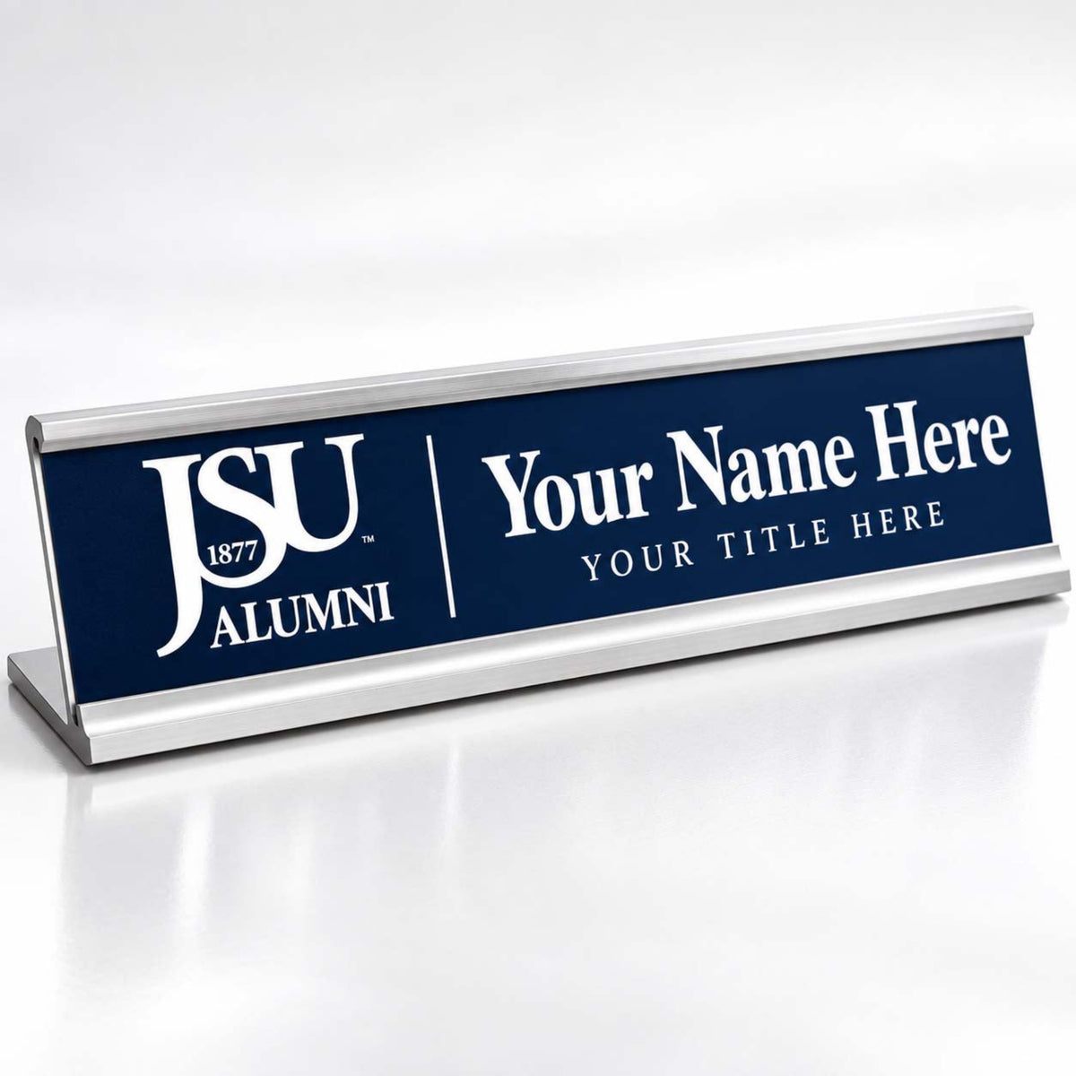 A personalized nameplate sign with a navy blue face and silver metal base, featuring the JSU 1877 Alumni logo and customizable text reading 'Your Name Here' and 'YOUR TITLE HERE'.