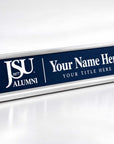 A personalized nameplate sign with a navy blue face and silver metal base, featuring the JSU 1877 Alumni logo and customizable text reading 'Your Name Here' and 'YOUR TITLE HERE'.