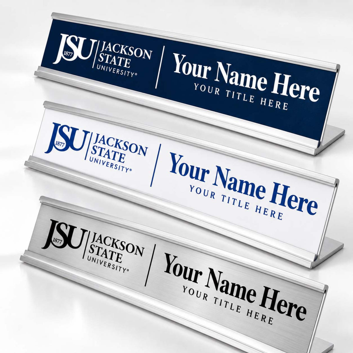 Three custom desk nameplates with Jackson State University branding, shown at different angles on a light gray background. The nameplates feature navy blue, white, and brushed silver metallic finishes with customizable text placeholders.