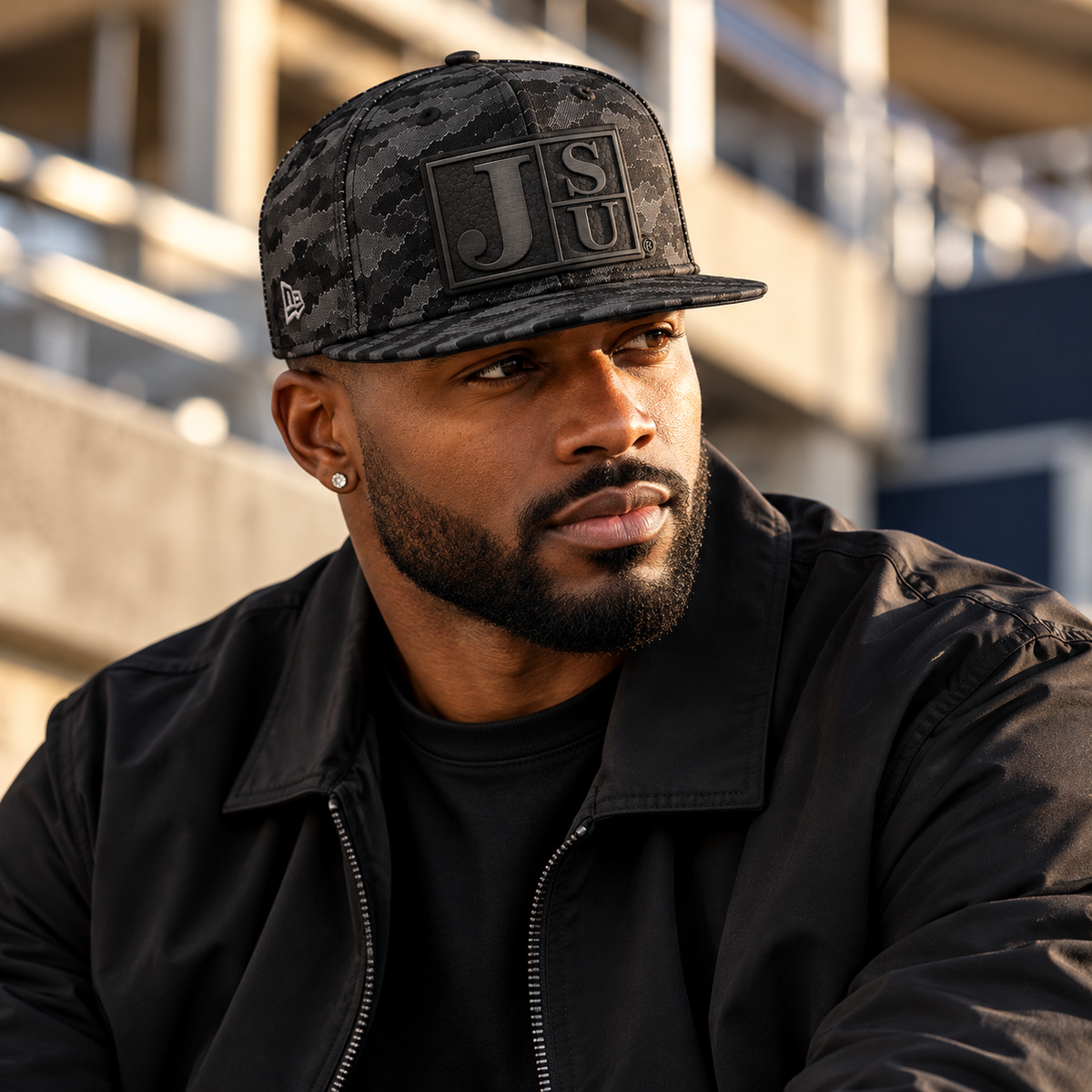 Black man wearing Jackson State Black Camo New Era 9FIFTY flat bill snapback with tone-on-tone black Block JSU leatherette patch