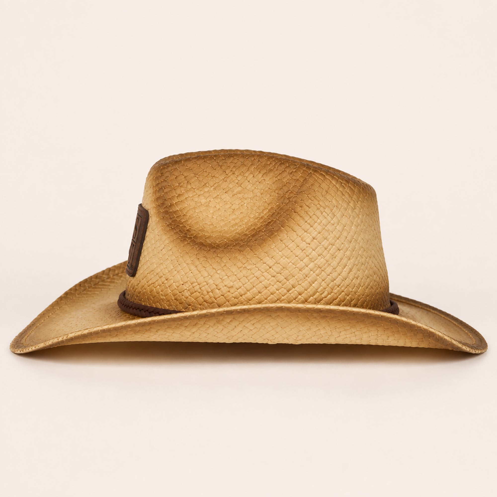 Side view of JSU natural raffia cowboy straw hat with braided leather band