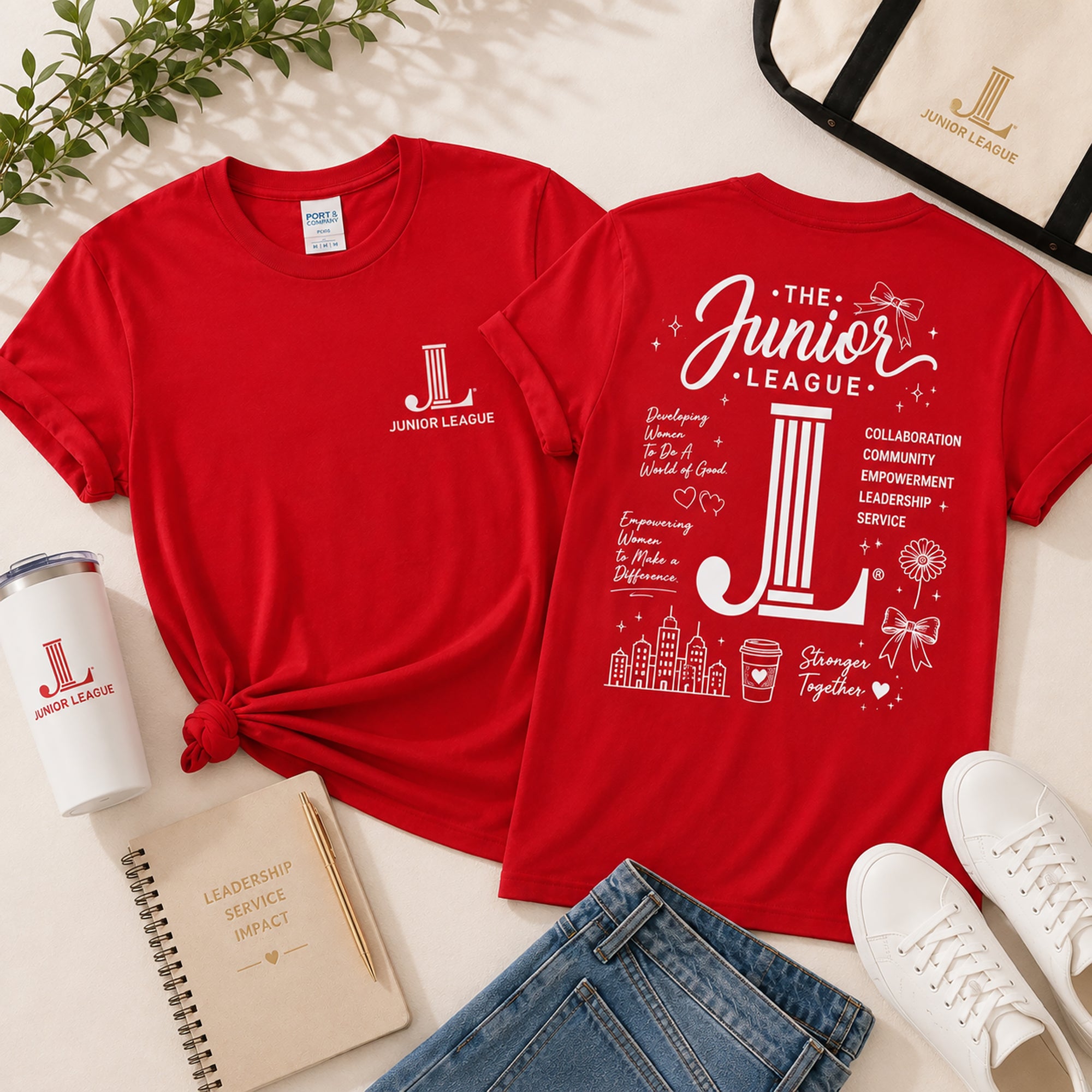 Junior League Women Who Build Essential Tee styled with tote bag, tumbler, notebook, denim, and sneakers in boutique flat lay