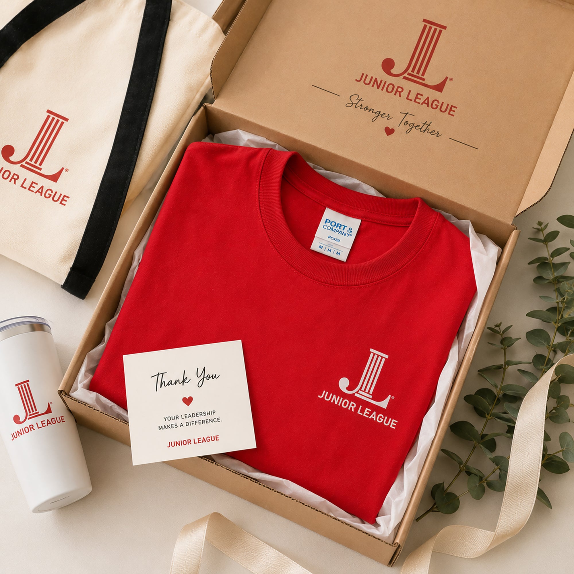 Junior League Women Who Build Essential Tee packaged in premium gift box with branded accessories and thank you card