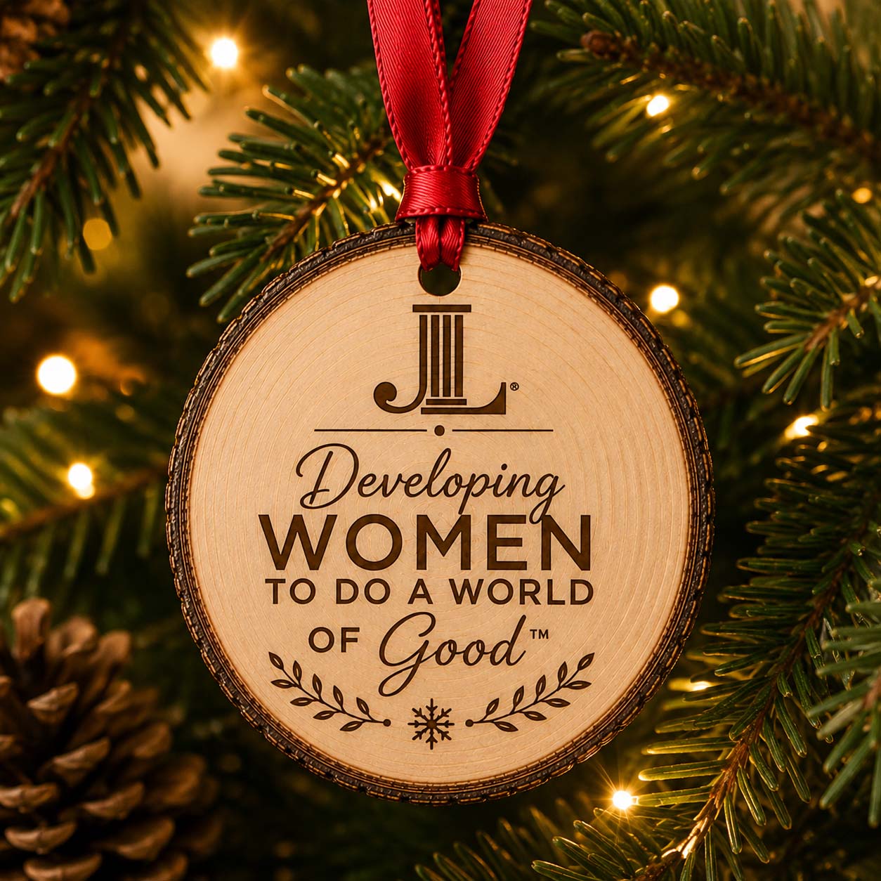 Junior League natural wood slice ornament centered on tree lights with red ribbon