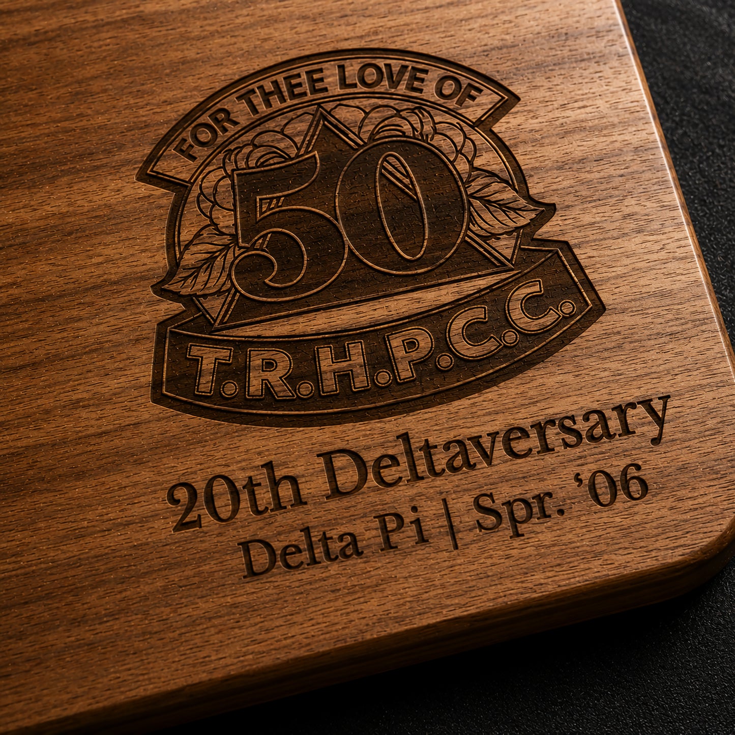 Close-up macro detail of laser engraved Delta Sigma Theta Deltaversary design on acacia wood cutting board