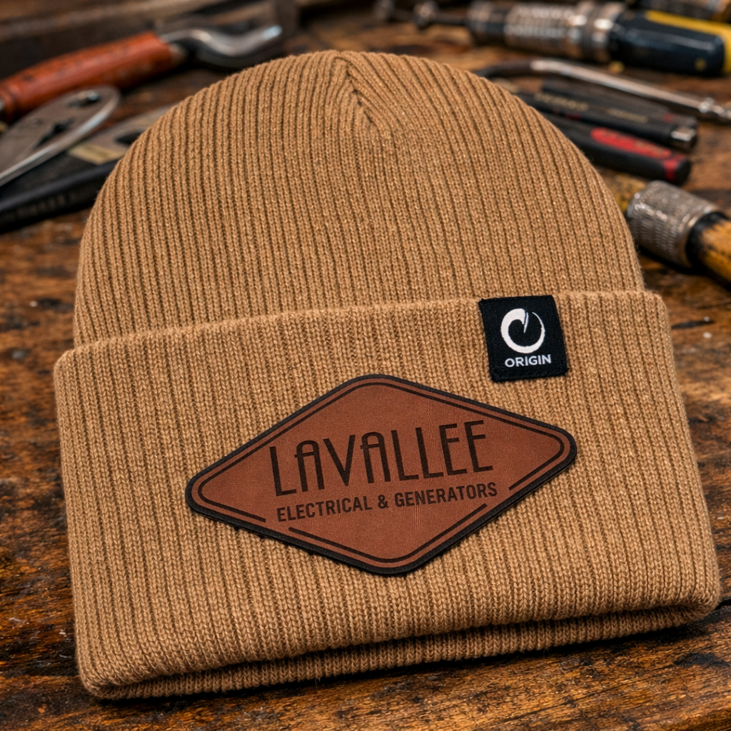 Custom Lavallee Electrical & Generators beanies featuring leatherette logo patch in walnut to black shown on a workbench for electricians and generator technicians