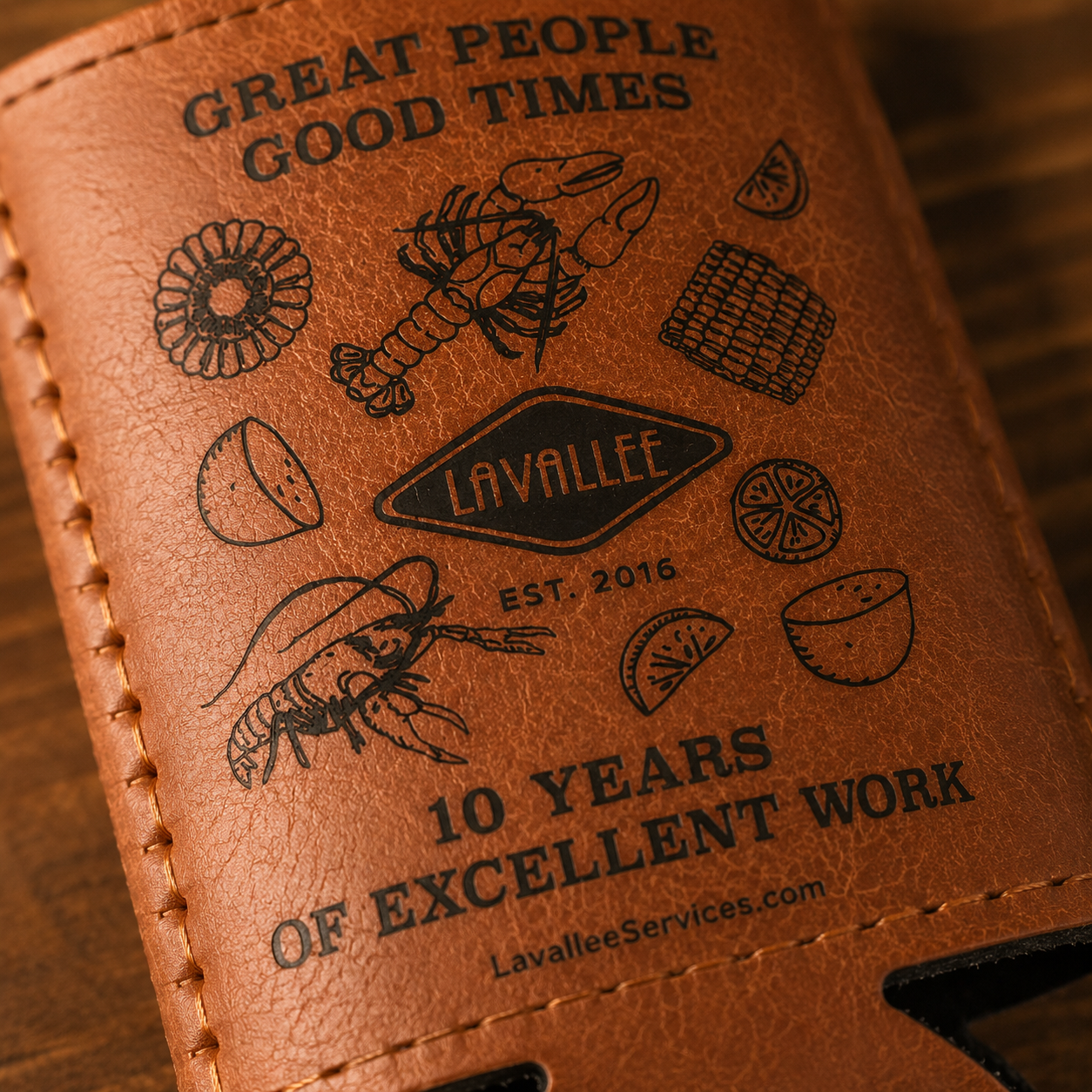 Macro close-up of LaVallee anniversary koozie showing premium print detail, stitching, leatherette texture, and crisp crawfish boil artwork.