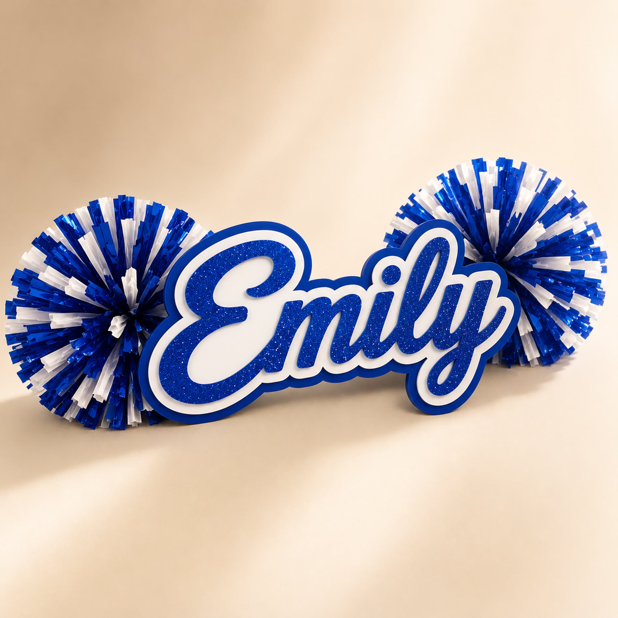 Personalized three-layer acrylic name spirit stick from the Classic Collection with coordinating pom-poms displayed on a luxury ivory background.