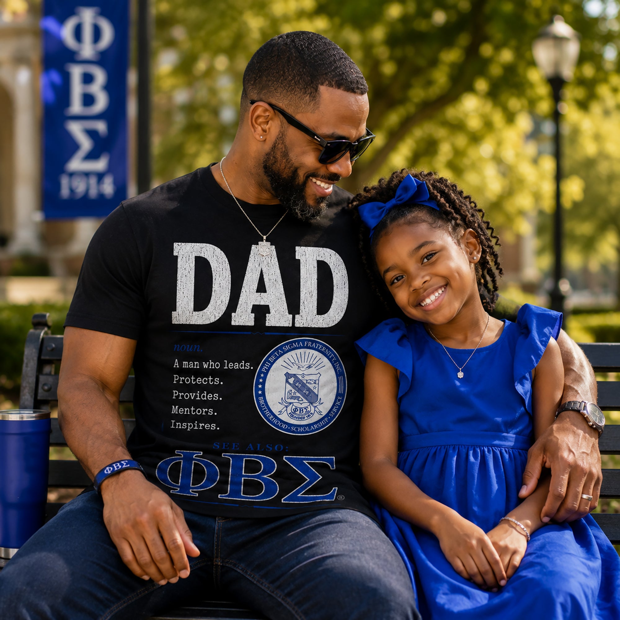 African American Phi Beta Sigma father wearing Sigma Dad definition shirt while spending time with his daughter outdoors