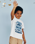 Toddler white T-shirt worn by a child, with JSU Rocks the House front graphic