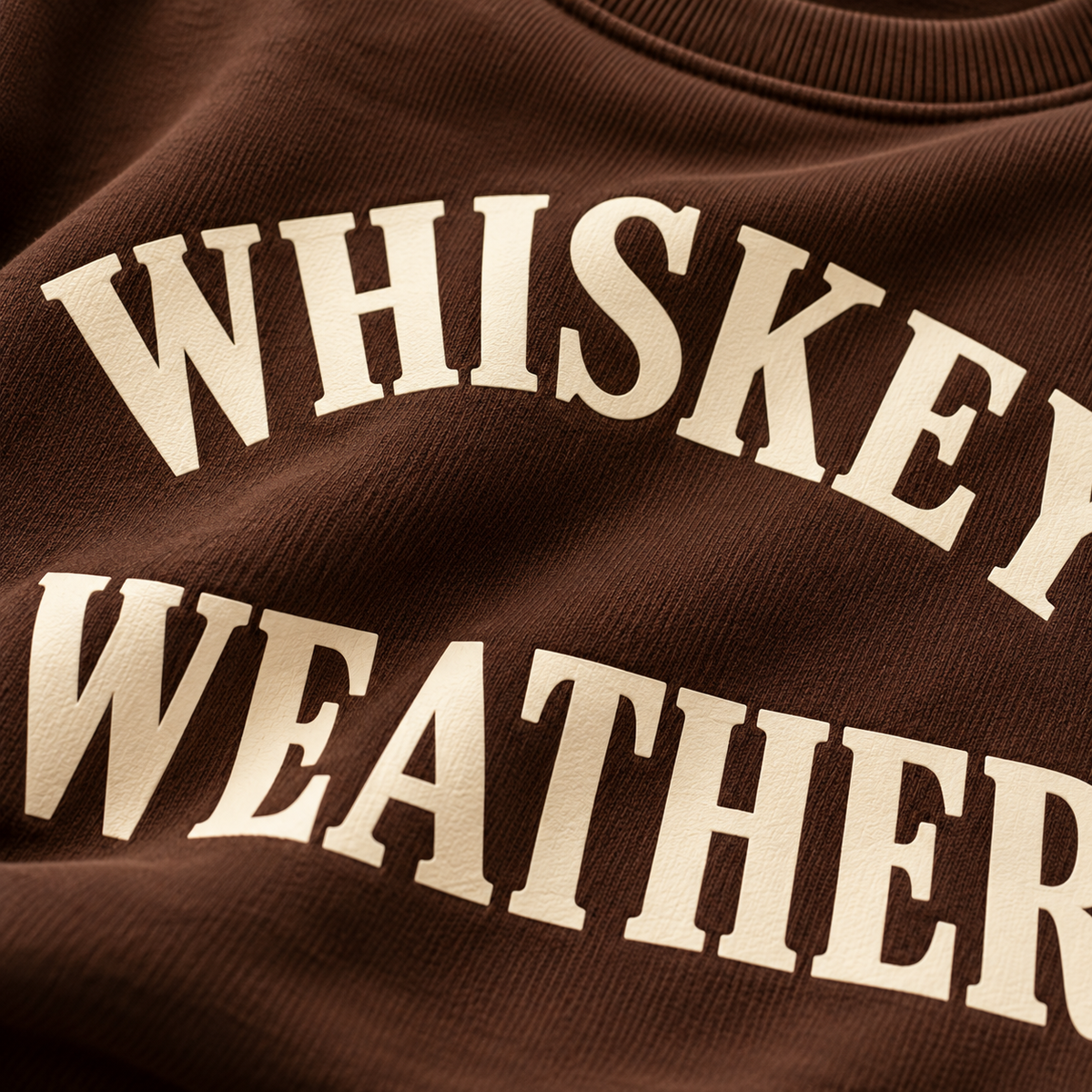 Close-up detail of warm cream Whiskey Weather print on Chocolate Brown sweatshirt
