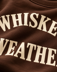 Close-up detail of warm cream Whiskey Weather print on Chocolate Brown sweatshirt