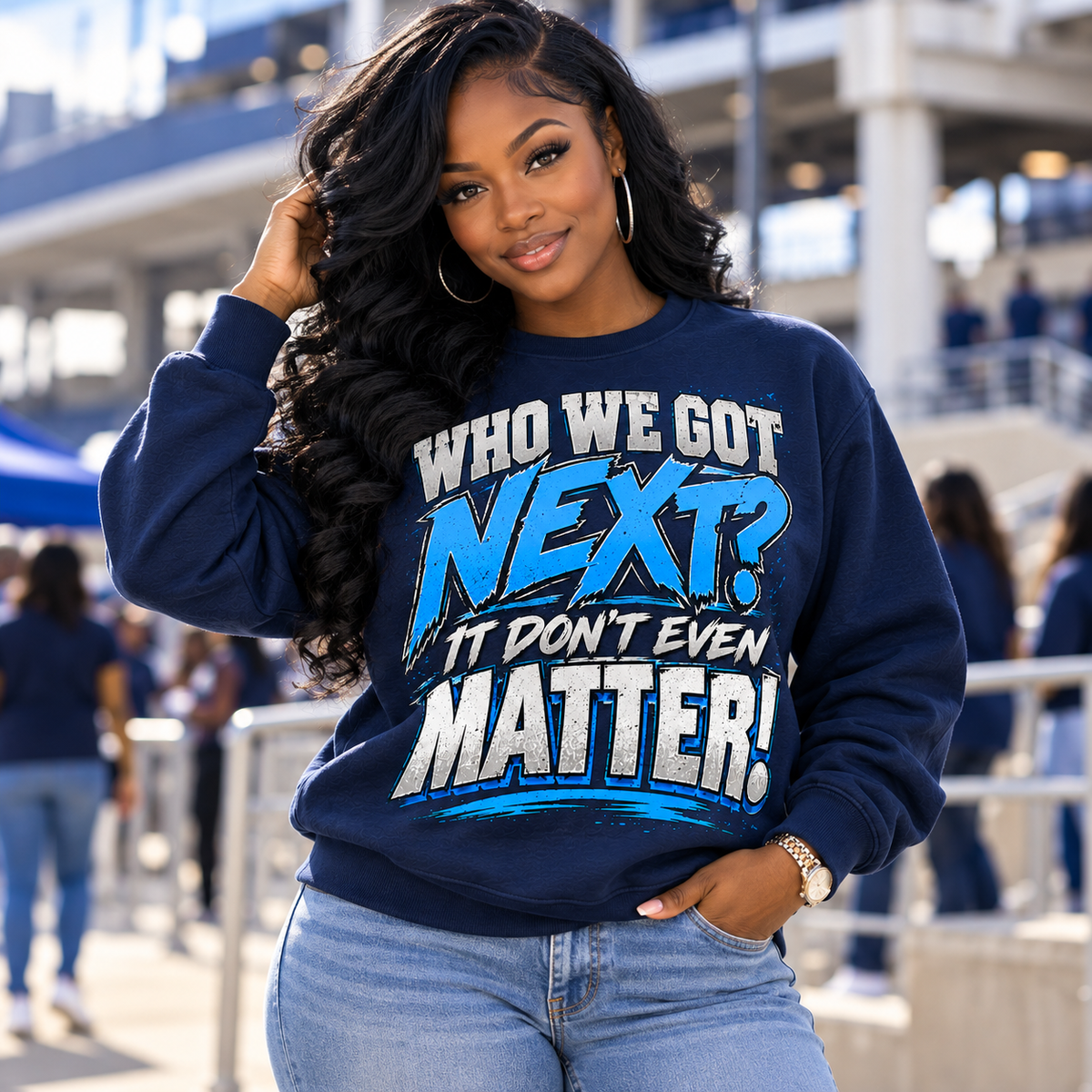 Black woman wearing navy Who We Got Next It Don't Even Matter crewneck sweatshirt in a game-day stadium setting