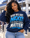 Black woman wearing navy Who We Got Next It Don't Even Matter crewneck sweatshirt in a game-day stadium setting