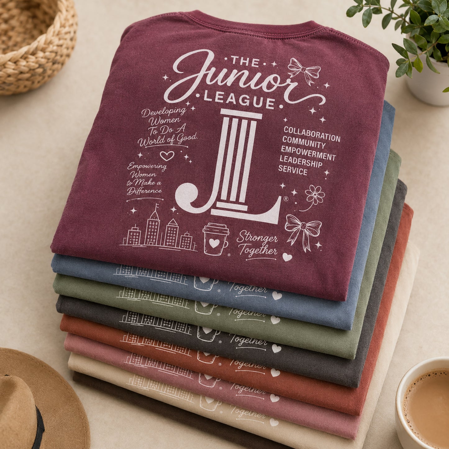 Folded stack of Women Who Build garment dyed tees in multiple boutique-inspired colorways
