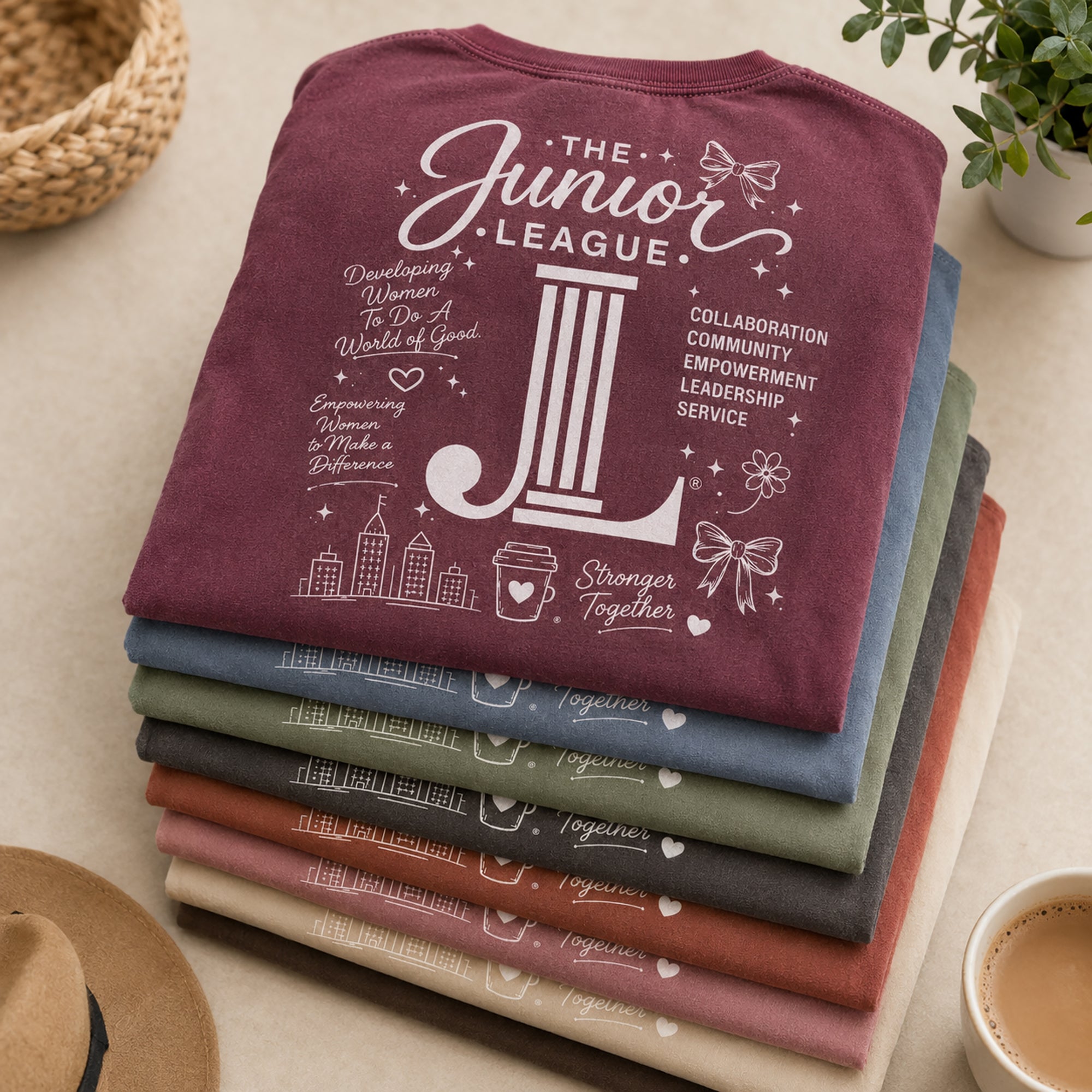 Folded stack of Women Who Build garment dyed tees in multiple boutique-inspired colorways