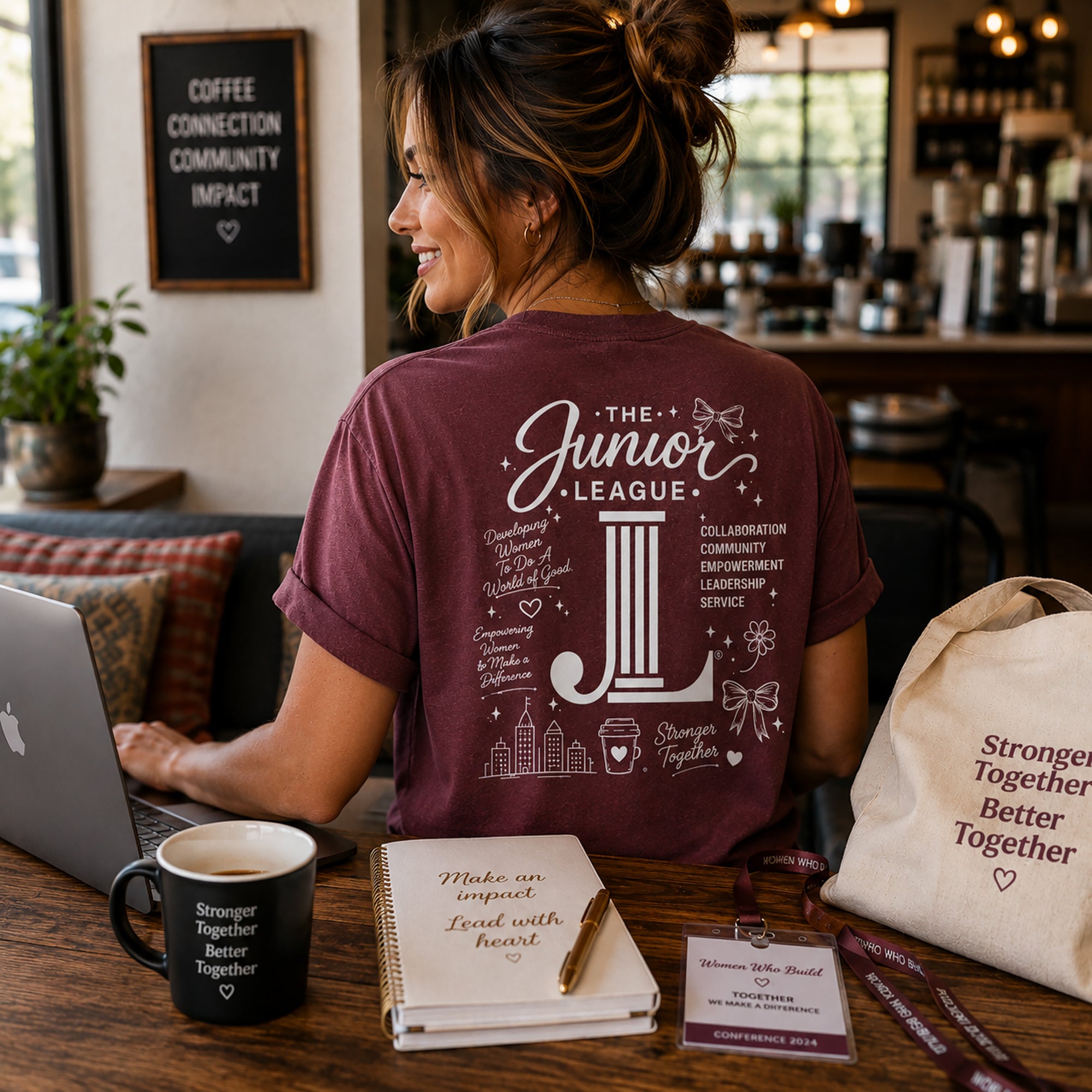 Woman wearing Women Who Build garment dyed graphic tee in a casual conference and coffee shop setting