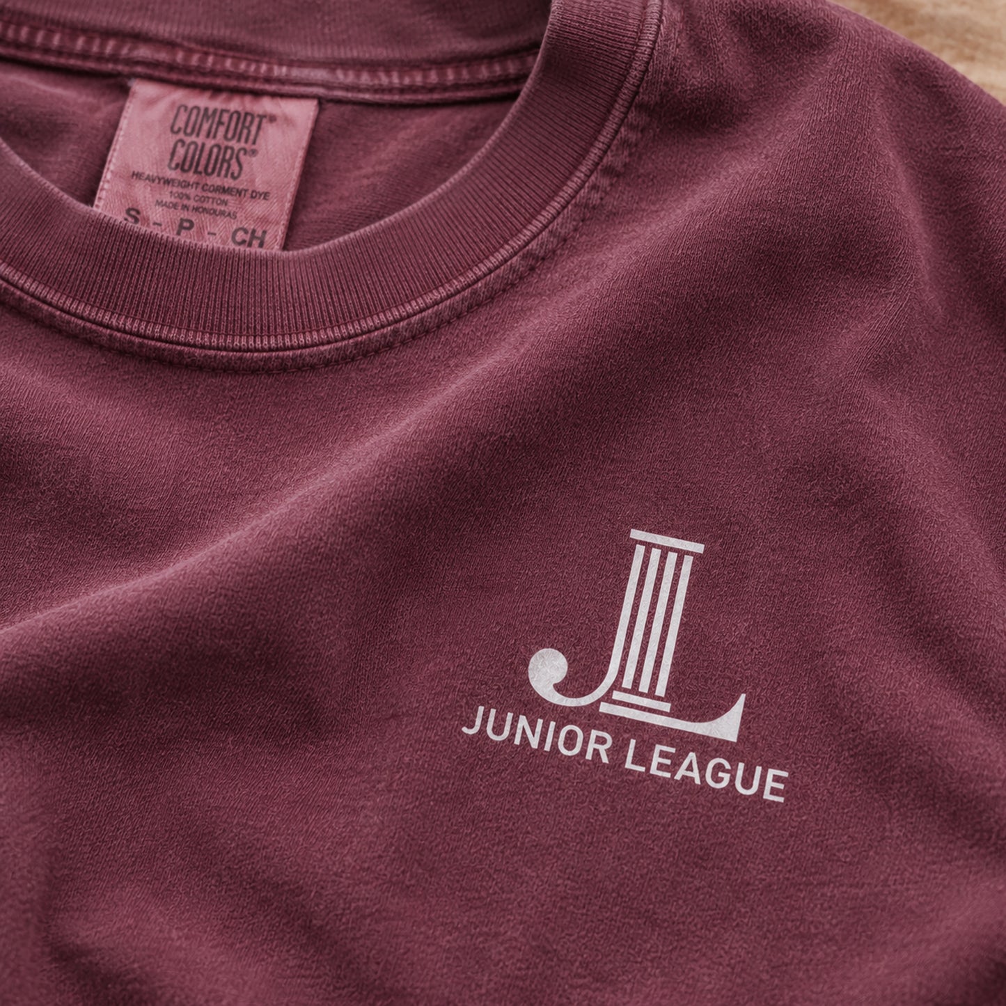 Close-up of the front chest JL logo on the Women Who Build Beach Wash Tee