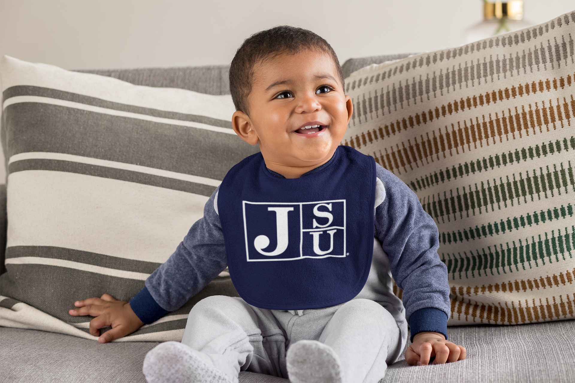 Infant bib on baby in navy blue with white JSU block letter logo