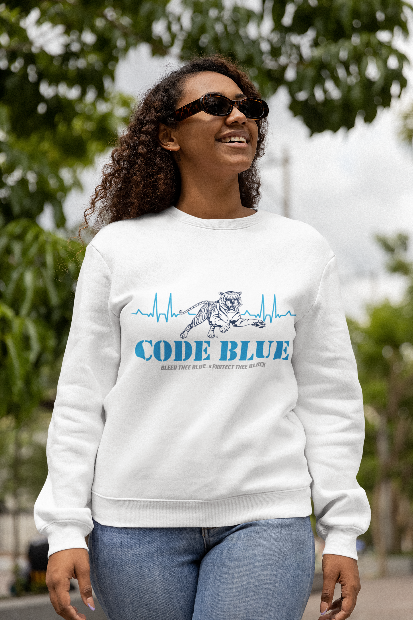 White crewneck sweatshirt with Code Blue graphic on chest, worn outdoors