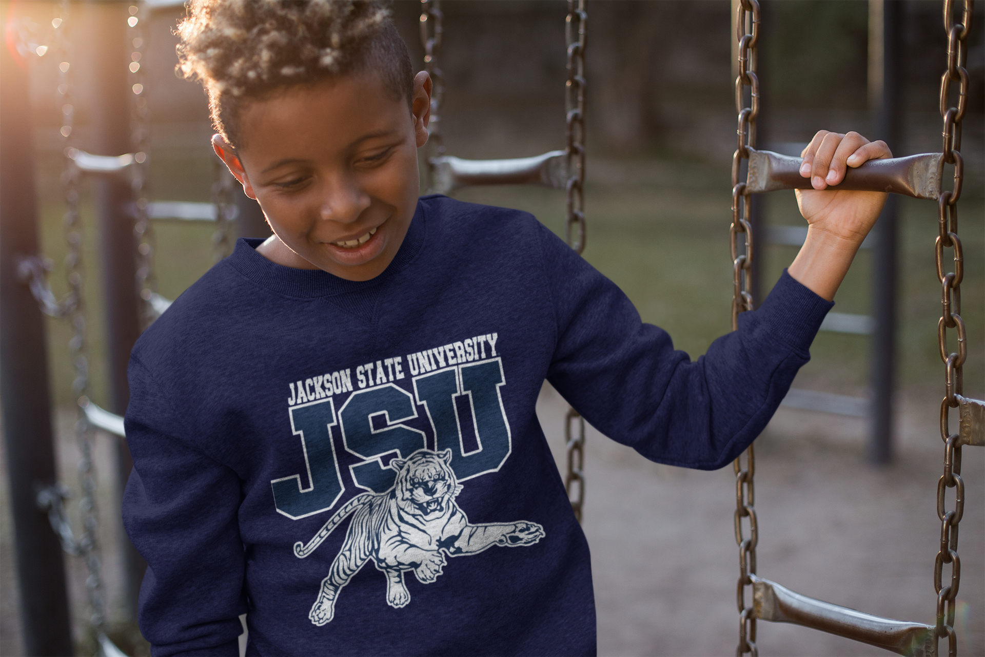 Youth crewneck sweatshirt in navy blue with leaping tiger logo, worn by child