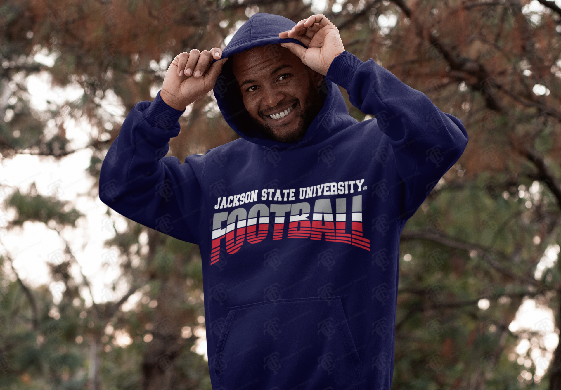 Navy pullover hoodie with Jackson State University Football tri-color logo, model adjusting hood