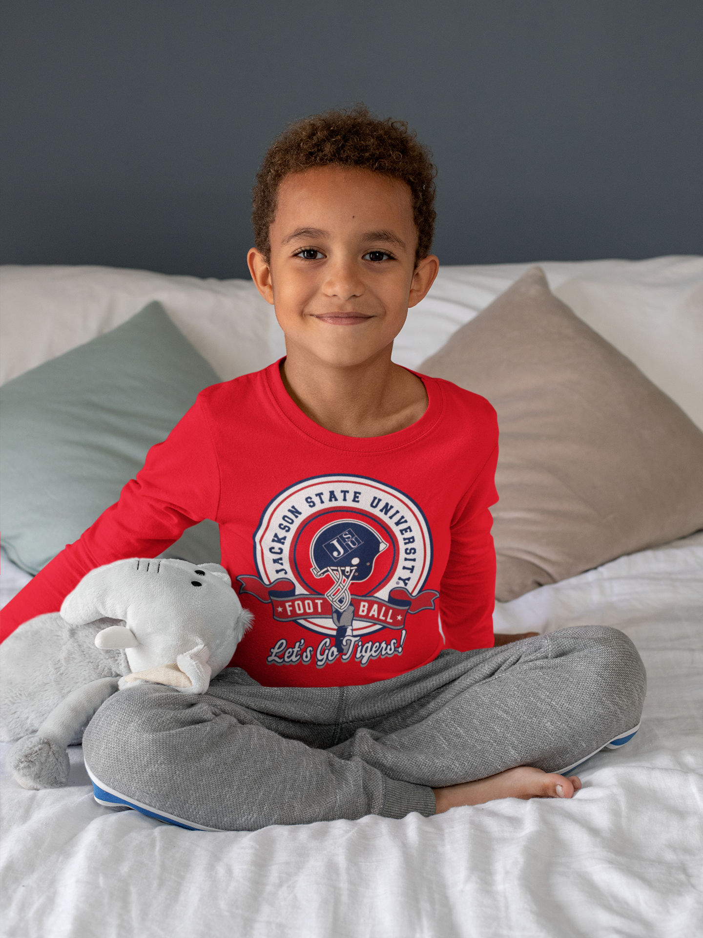Red toddler long sleeve T-shirt worn by child, featuring circular sports logo