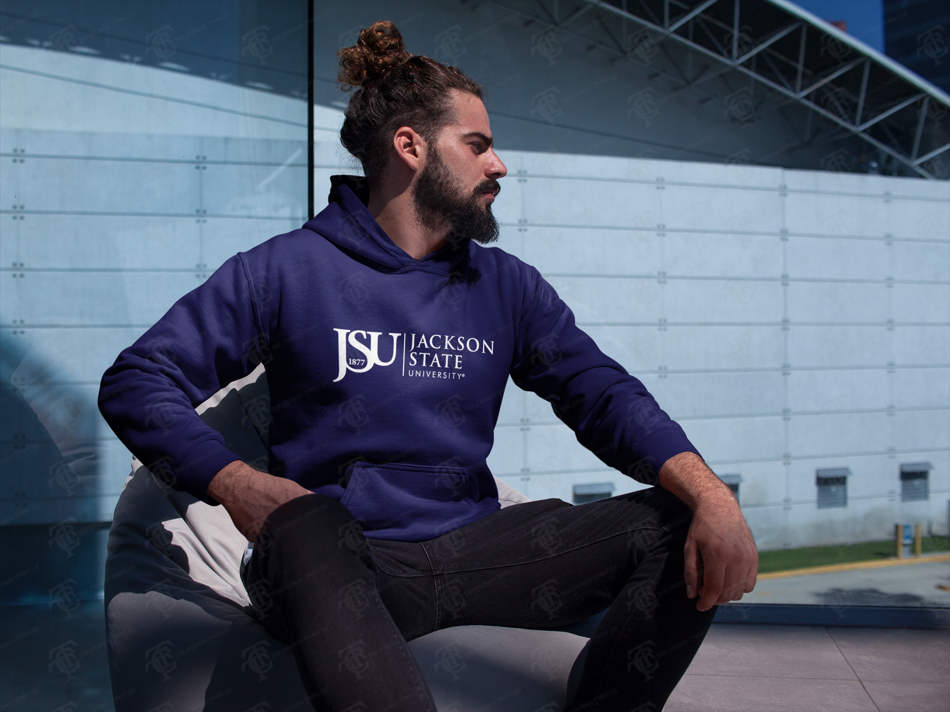 Navy pullover hoodie on model sitting, with front kangaroo pocket and Jackson State logo